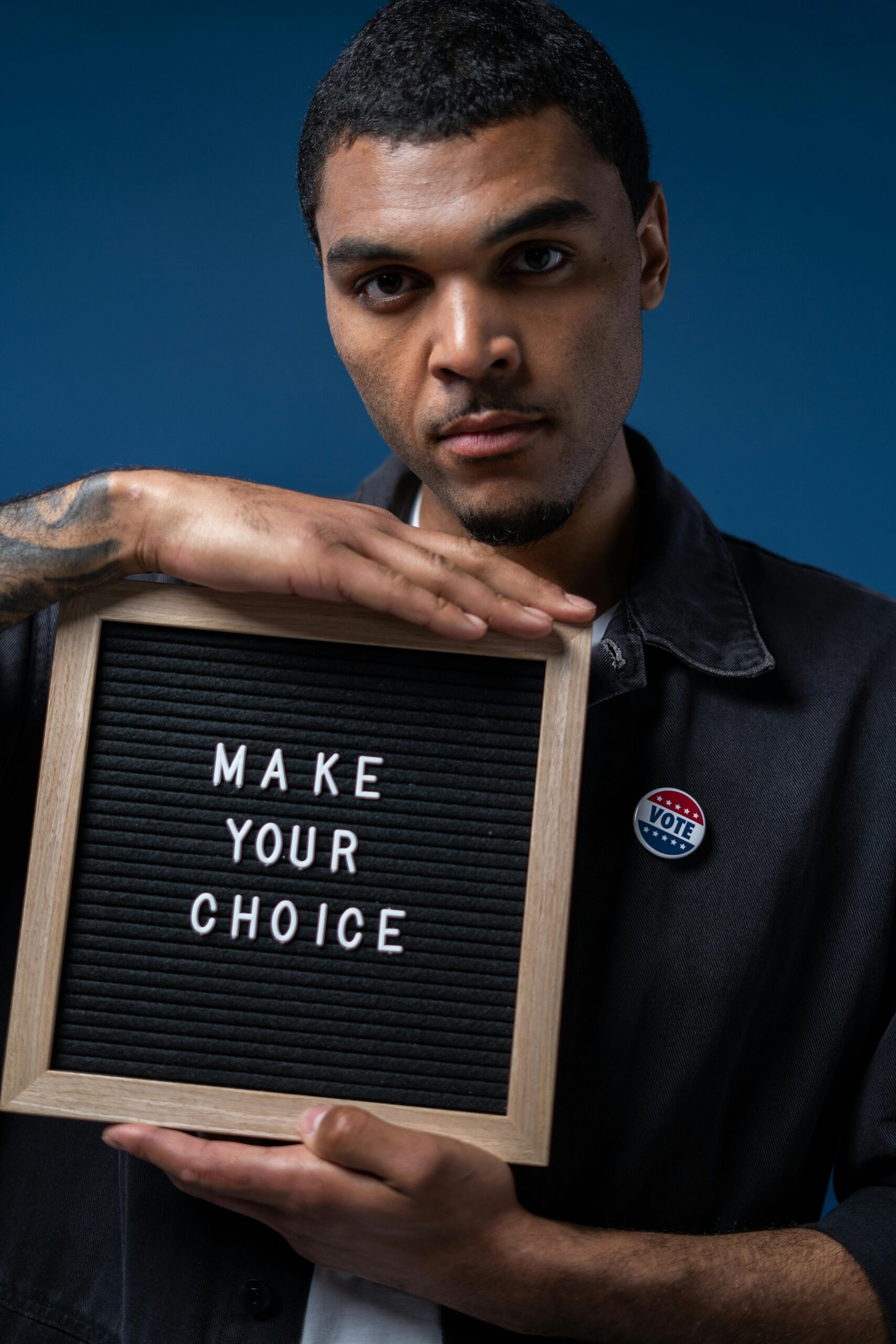 Serious man with 'make your choice' sign highlights the importance of voting and civic duty.
